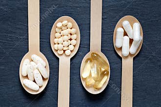 Different healthy supplements on wooden spoons