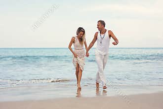 Cheerful couple in summer clothes on the beach
