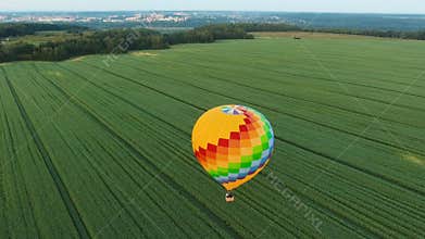 Hot air balloon in the sky over a field.