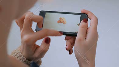 Woman using smartphone with augmented reality app and exploring virtual model