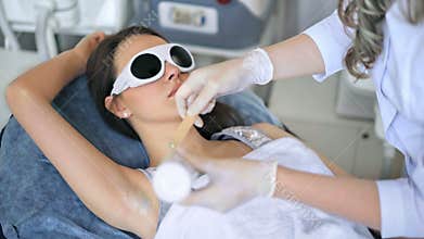 Beautiful woman getting permanent laser hair removal at beauty salon.