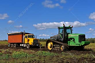 John Deere tractor pulling beet truck in the mud