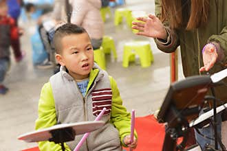Kid playing percussion instrument at street