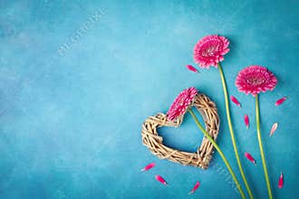 Spring background with pink flowers, heart and petals. Greeting card for Woman day. Flat lay style. Top view.
