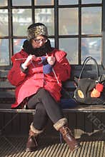 Woman knitting on a bench