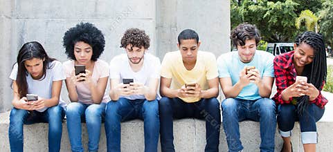 Group of young adults playing online game with phone