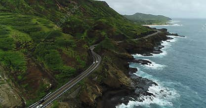 4K Drone Coastal Roadway Rocky Shore Crashing Waves Mountainside Flying Backwards