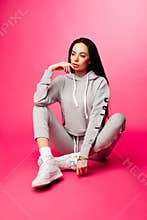 Gorgeous woman with long dark hair in sportive costume and sneak