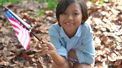 Little girl holding American flag at park