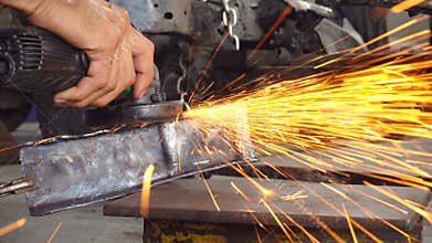 Metal worker grinding in auto body repair shop