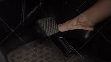 Female leg in high heels pressing the brake pedal