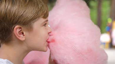 Baby eating cotton candy in the Park. Sweet and airy dessert. The day of the birth of the child.