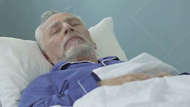 Senior man lying in bed and sleeping, healthy sound sleep, time in retirement