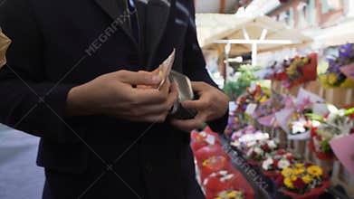 Man paying money to flower market seller for chic bouquet for his beloved