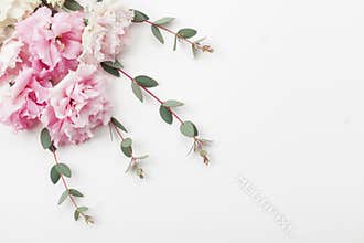 Bunch of beautiful flowers and eucalyptus leaves on white table top view. Flat lay style.