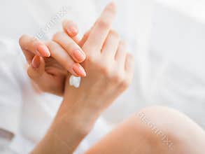 Closeup of female hands applying hand cream
