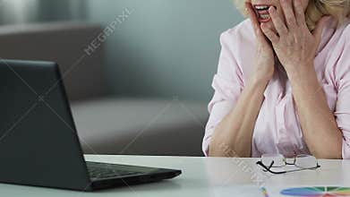 Lucky lady in her 50s reading winner list online, rejoicing her lottery victory
