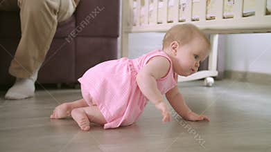 Baby crawling on floor at home. Sweet childhood. Toddler walking in home