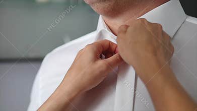 Woman helping her husband to put on shirt