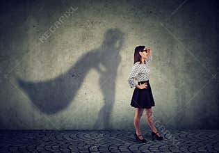 Brave young business woman posing as super hero