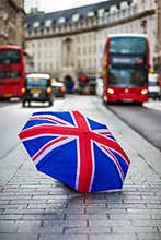 London, England - British umbrella at busy Regent Street with iconic red double-decker buses and black taxi
