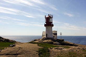 Photo of Lindesnes beacon in summer, South Norway. Aerial shot. Rocky sea coast and blue sky.