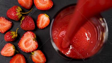 Fresh strawberry smoothie flowing in glass