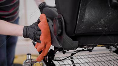 Master is wiping auto seats and smearing fittings by oil in auto-service, cleaning of automobiles