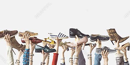 Hands holding different shoes on isolated background