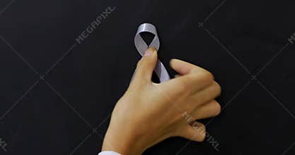 Hand attaches Gray ribbon on the chalkboard