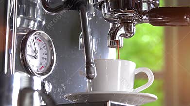 Espresso out of classic coffee machine into coffee cup