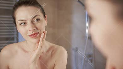 Woman applying foundation near mirror