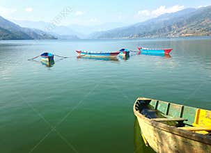 Five nice multicolore tourist boats of Lake Pheva, mountains and clouds