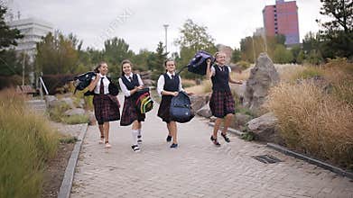 Happy College student in the same school uniform in a hurry home after lessons.