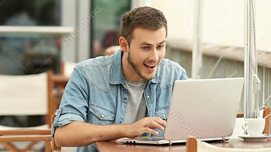 Excited man reading good news in a laptop
