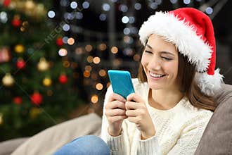 Woman texting on the phone in christmas at home