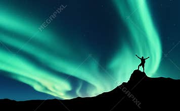 Northern lights and silhouette of standing happy man. Aurora