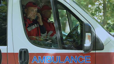 Male paramedic answering on patient's call, professional ambulance crew, 911