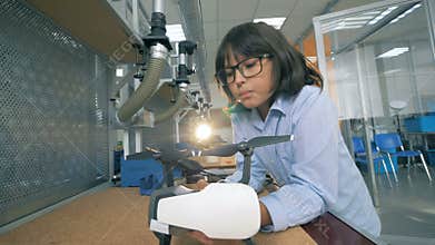 A child fixing a drone in a laboratory, close up.
