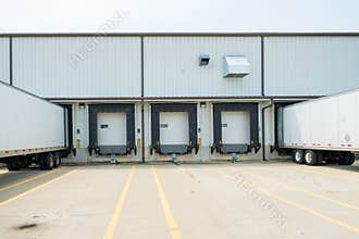 Warehouse building with 53 foot dry van trailers backed into doc