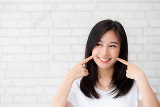 Portrait of beautiful young asian woman happiness standing finger touch cheek on gray cement texture grunge wall brick background