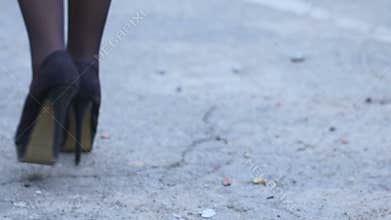 Tired lady in high heel shoes walking street, returning after nightclub party