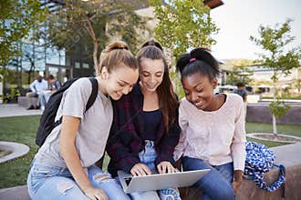 Female High School Students Using Digital Devices Outdoors During Recess