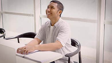 Blind man reading a braille book in library