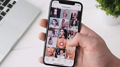 Yekaterinburg, Russia - October 3, 2018: Man using Instagram app on iPhone X smartphone, browsing through Kim Kardashian