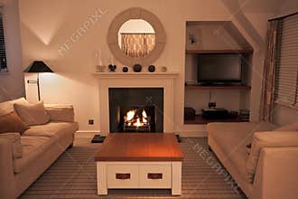 Luxurious modern living room with lit fire