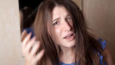 Young girl is very upset by the position of the hair. Bad hairstyle, hair restoration