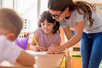 Preschool teacher looking at smart child at kindergarten