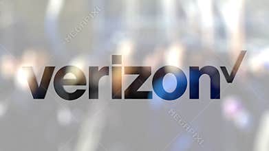 Verizon Communications logo on a glass against blurred crowd on the steet. Editorial 3D rendering
