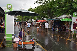 Popular Chatuchak Weekend Market during Rainy Season with visitors holding umbrellas